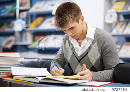 Handsome male student in a library Handsome male student in a library 9727284