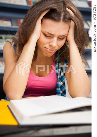 Stressed female student in a university library Stressed female student in a university library 9727285