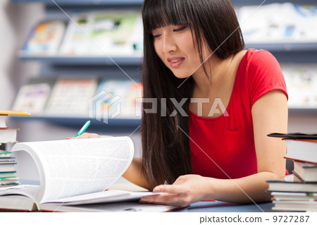 Beautiful female student in a library Beautiful female student in a library 9727287