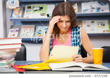 Stressed female student in a library 9727290