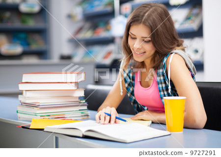 Beautiful female student in a library Beautiful female student in a library 9727291