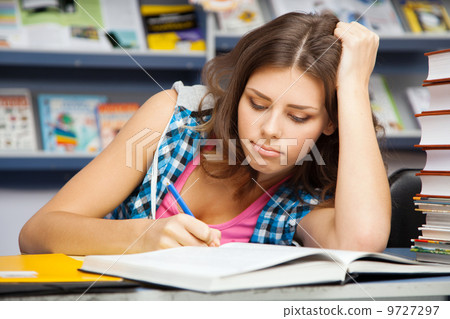 Beautiful female student in a library 9727297