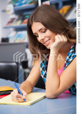 Beautiful female student in a library Beautiful female student in a library 9727300