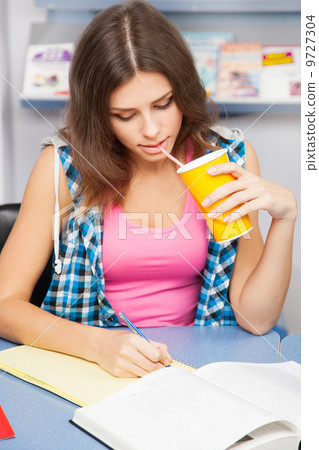 Beautiful female student in a library Beautiful female student in a library 9727304