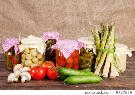 Fresh and canned vegetables on a wooden table Fresh and canned vegetables on a wooden table 9727659