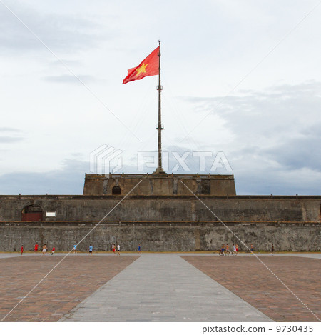HUE, VIETNAM - AUG 4: Boys playing football in front of the Flag 9730435