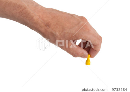Hand holding a yellow pawn 9732384
