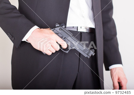 Man with gun, business suit, focus on the gun Man with gun, business suit, focus on the gun 9732485