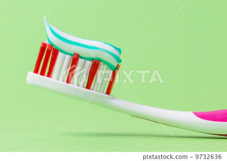 A pink toothbrush with toothpaste 9732636