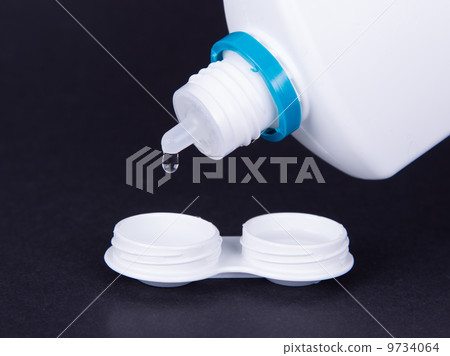 Lens casing and bottle of water isolated on black 9734064
