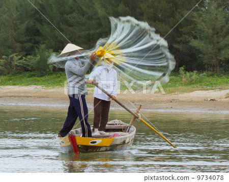 Fisherman is fishing with a large net in a river in Vietnam 9734078