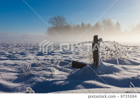 Barbed wire fence with snow covered ground Barbed wire fence with snow covered ground 9735084