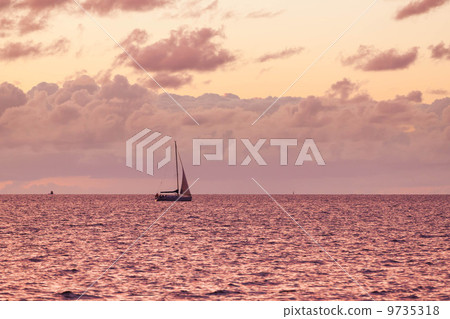 A solitary sailboat in the open sea 9735318