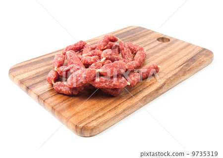 A heap of mini Salamis on wooden board 9735319