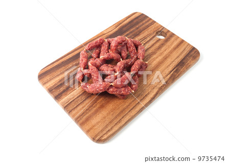 A heap of mini Salamis on wooden board 9735474