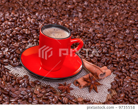 Coffee in a red cup with cinnamon and anise stars. 9735558