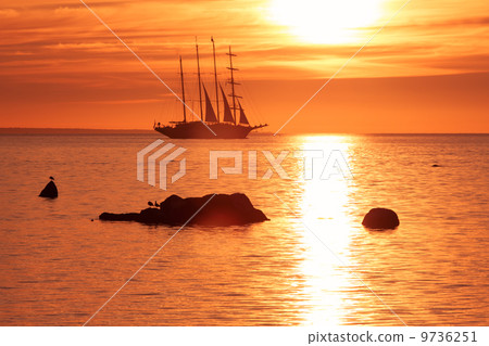 Tall ship sailing in red sunset 9736251