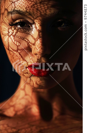 Reflection. Woman in Shadows with Reflection of Openwork Lace on her Face 9744873