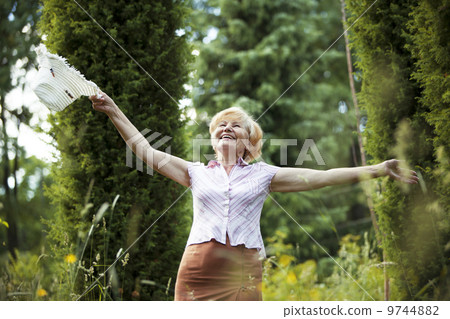 Freedom. Happy Old Lady with Hut smiling in The Garden. Lifestyle 9744882