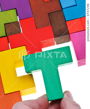 placing T-shaped piece in wooden puzzle placing T-shaped piece in wooden puzzle 9747296