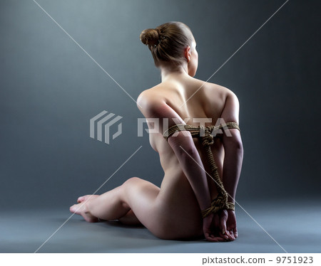 Rear view of nude slim woman tied with rope 9751923