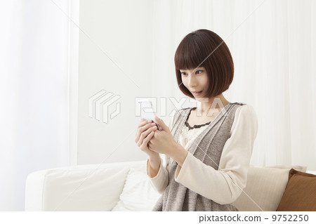 A woman watching a smartphone A woman watching a smartphone 9752250