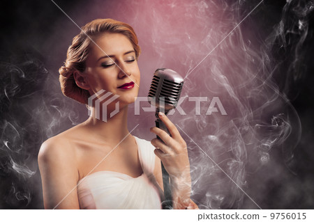 beautiful blonde woman singer with a microphone 9756015