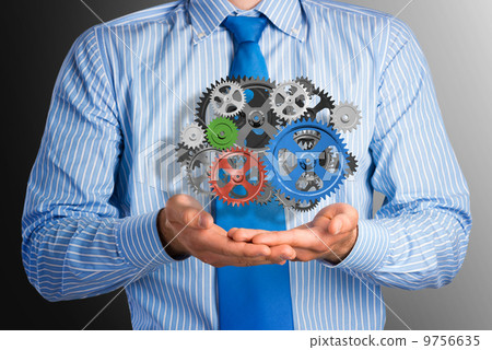 business man holds up a mechanism of gears business man holds up a mechanism of gears 9756635