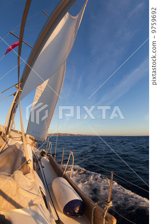 Sailboat during the regatta at sunset ocean 9759692