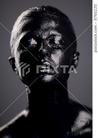 girl in black paint on dark background 9760220