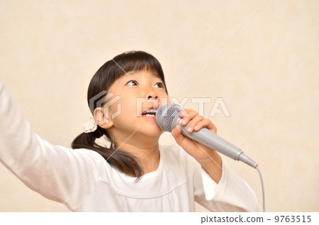 一個女孩用麥克風唱歌 9763515