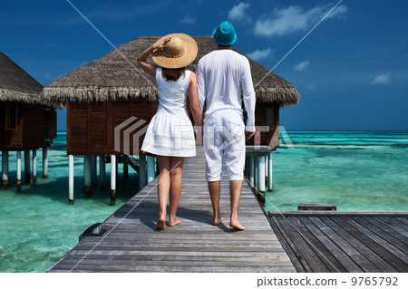Couple on a beach jetty at Maldives 9765792