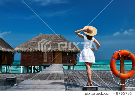 Woman on a beach jetty at Maldives Woman on a beach jetty at Maldives 9765795