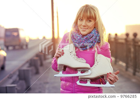 Beautiful smiling blond woman with ice skates 9766285