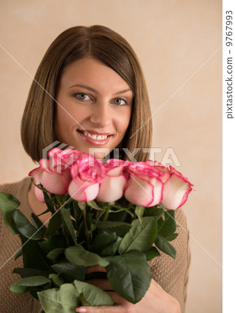 Pretty brunette woman holding bunch of roses Pretty brunette woman holding bunch of roses 9767993