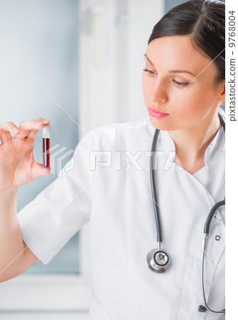 Portrait of pretty female laboratory assistant analyzing a blood Portrait of pretty female laboratory assistant analyzing a blood 9768004