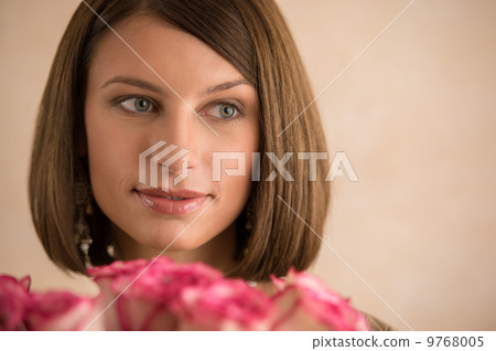 Pretty brunette woman holding bunch of roses 9768005