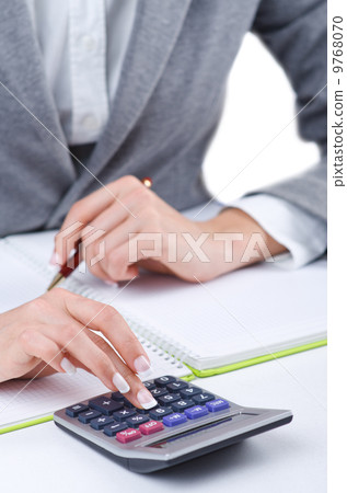 Hands working on the calculator 9768070