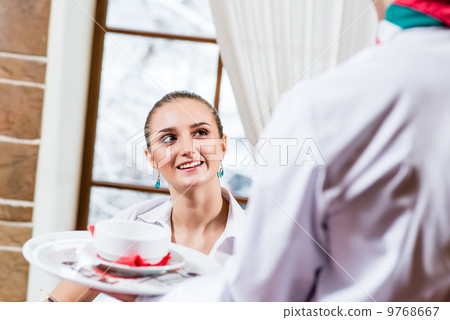 waiter brings a dish for a nice woman 9768667