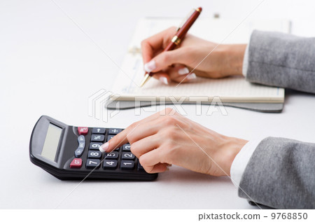 Hands working on the calculator Hands working on the calculator 9768850