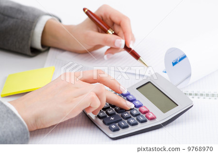 Hands working on the calculator Hands working on the calculator 9768970