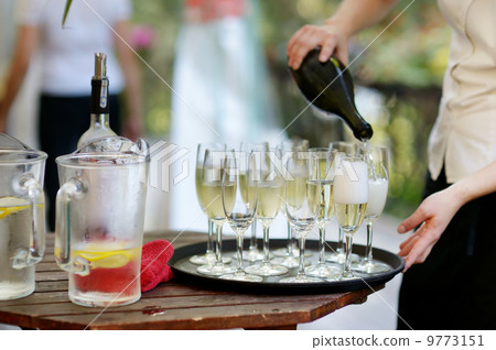 Pouring champagne into a glasses Pouring champagne into a glasses 9773151