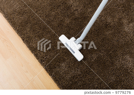 Brown carpet with vacuum cleaner in living room 9779276