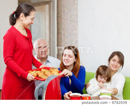 family communicate over tea with cakes 9782039