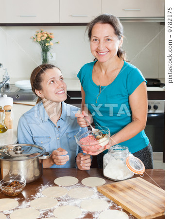 daughter with mature mother cooking meat dumplings 9782175