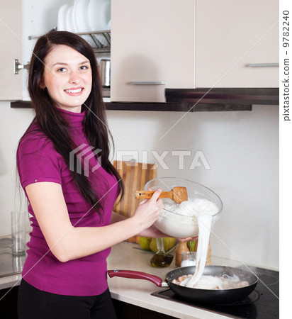 Woman cooking chinese noodles with seafood Woman cooking chinese noodles with seafood 9782240