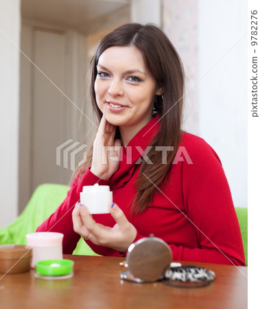 woman puts cream on face 9782276