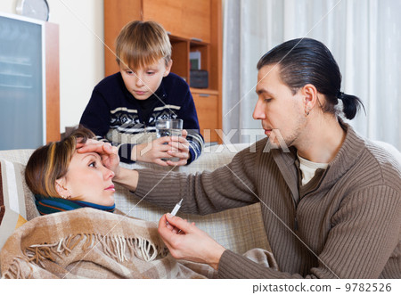 Man measuring the temperature of unwell wife Man measuring the temperature of unwell wife 9782526