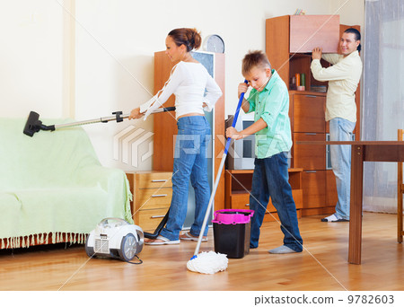 Ordinary family of three with teenager doing housework 9782603