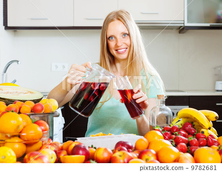 Happy woman pouring beverages with fruits 9782681
